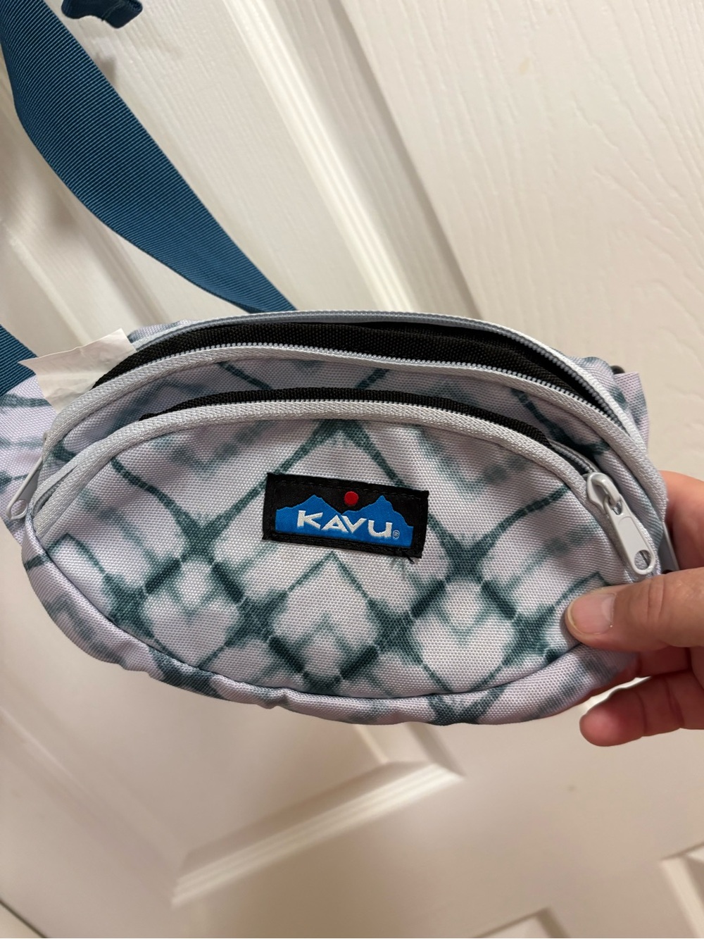Kavu Spectator fanny pack features an "Ocean Dye" grey and green tie-dye pattern